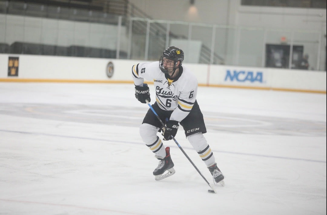 Hockey player, Thomas Patterer, on the ice with NCAA logo in the background